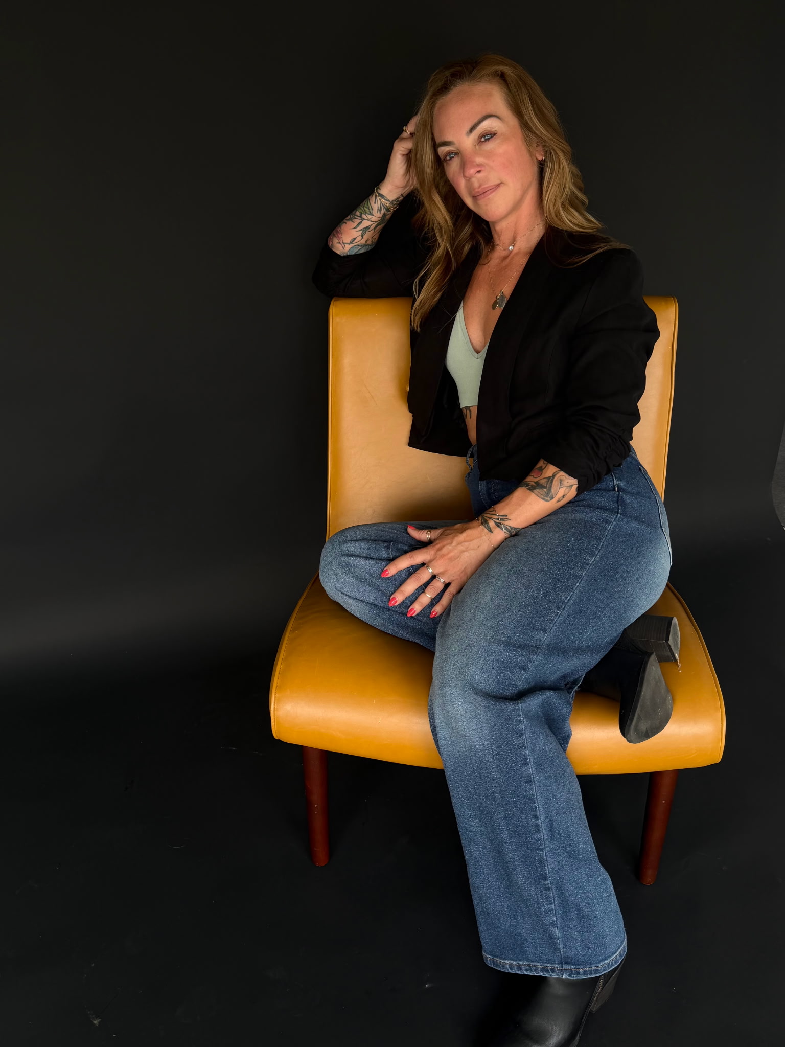 Portrait of Belle seated against a black studio backdrop.